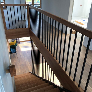 Nowoczesne schody drewniane z balustrada typu harfa